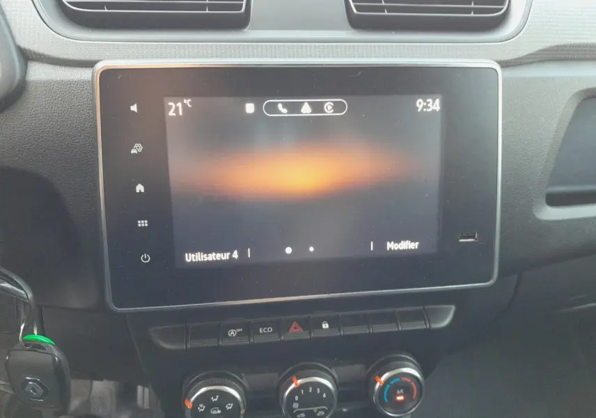 Écran tactile central allumé avec commandes climatisation et boutons fonctionnels du Renault Express Van blanc, vue intérieure frontale.