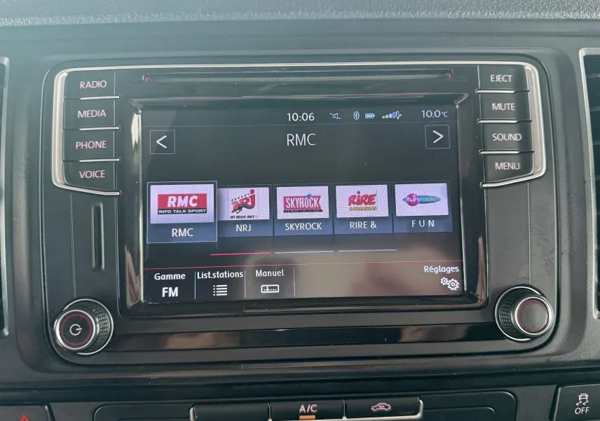 Écran tactile de la radio multimédia du Volkswagen Transporter rouge, vue frontale centrée sur l'interface FM.