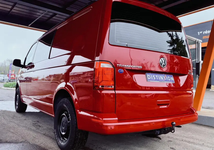 Vue 3/4 arrière droite d’un Volkswagen Transporter Chassis Double Cabine rouge de 2017 avec attelage et jantes noires.