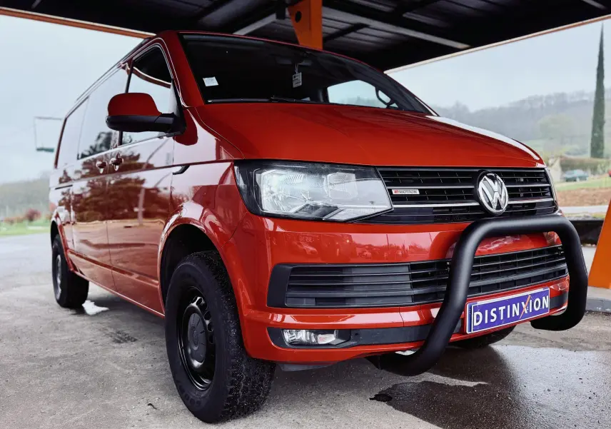 Vue 3/4 avant gauche d’un Volkswagen Transporter Chassis Double Cabine rouge 2017 avec pare-buffle noir et plaques Distinxion.