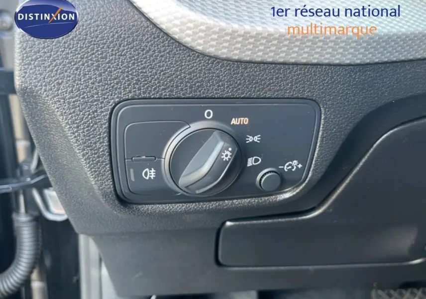 Gros plan sur le bouton de commande des phares dans l'habitacle noir de l'Audi Q2 35 TFSI S-Line 2023.