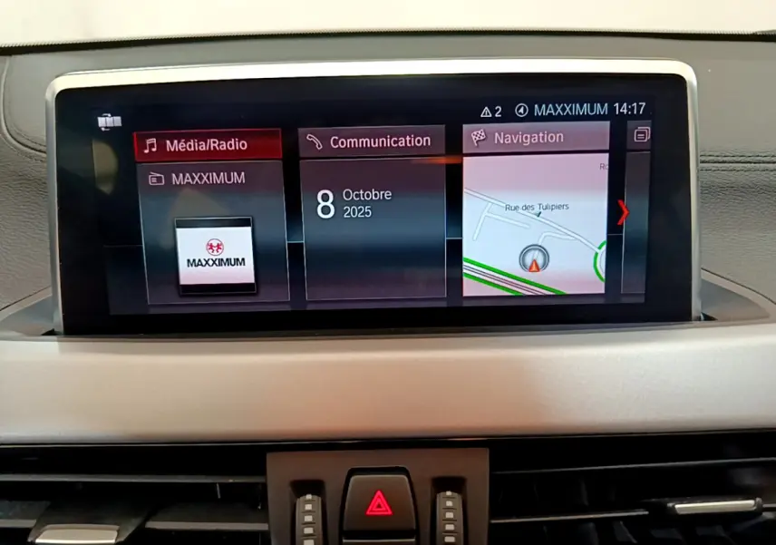 Écran central tactile du tableau de bord du BMW X2 blanc 2023 affichant navigation et médias.