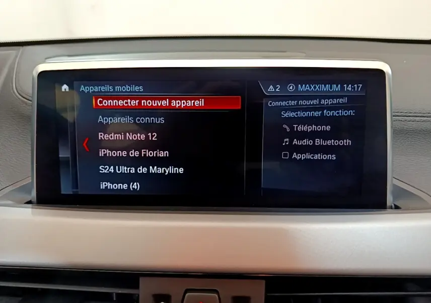Écran central tactile de la BMW X2 blanc 2023 affichant le menu de connexion Bluetooth des appareils mobiles.