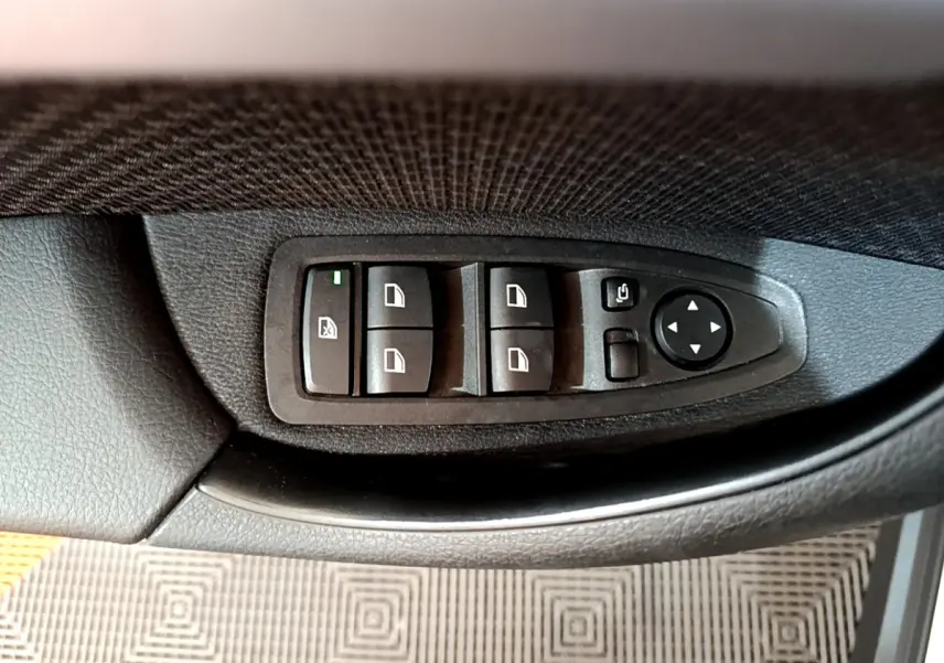 Panneau de commandes des vitres et rétroviseurs côté conducteur intérieur noir de BMW X2 blanc 2023.