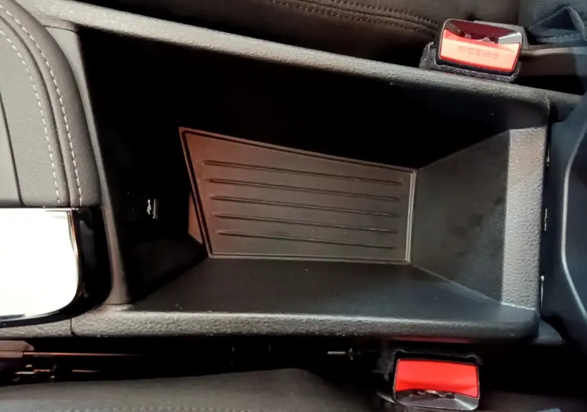 Vue rapprochée de la console centrale noire du BMW X2 sDrive18i 2023 avec boutons de ceinture rouges visibles.