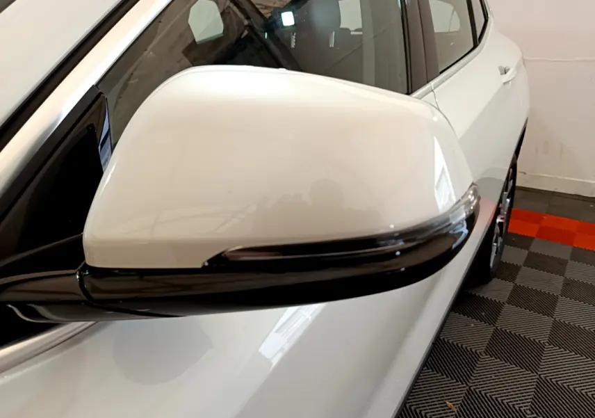 Rétroviseur droit blanc avec clignotant intégré sur BMW X2 blanc vue rapprochée côté passager arrière.