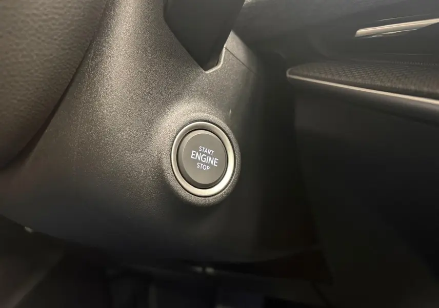 Bouton start/stop moteur en gros plan sur le tableau de bord noir du Skoda Superb Combi 2025 gris argent.