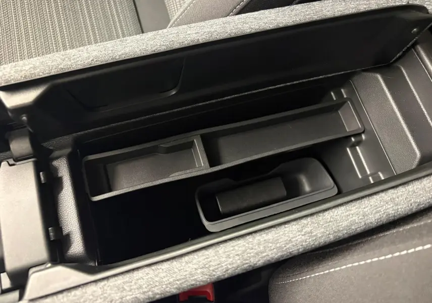 Vue rapprochée de l'accoudoir central ouvert du Skoda Superb Combi gris argent, montrant le rangement intérieur.