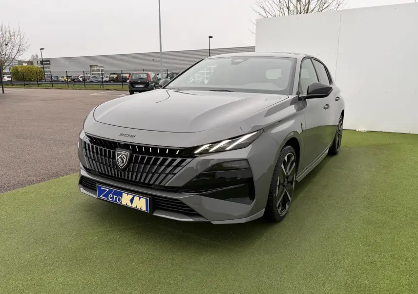 Peugeot 308 gris selenium vue 3/4 avant droit, calandre noire avec logo lion et jantes alliage noires.