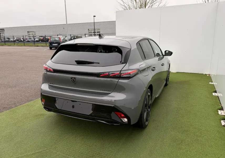 Vue 3/4 arrière droite de la Peugeot 308 III hybride gris selenium avec feux arrière LED et jantes alliage noires.