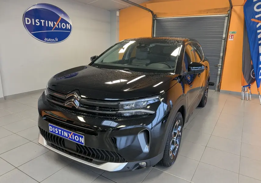 Citroën C5 Aircross noir vue 3/4 avant droit en intérieur, avec jantes alliage 18 pouces et calandre distinctive.