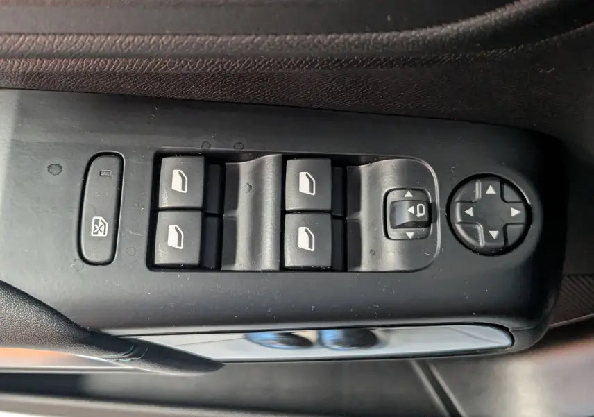 Vue rapprochée des commandes de lève-vitres et réglages des rétroviseurs côté conducteur d'une Citroën C5 Aircross noir 2024.