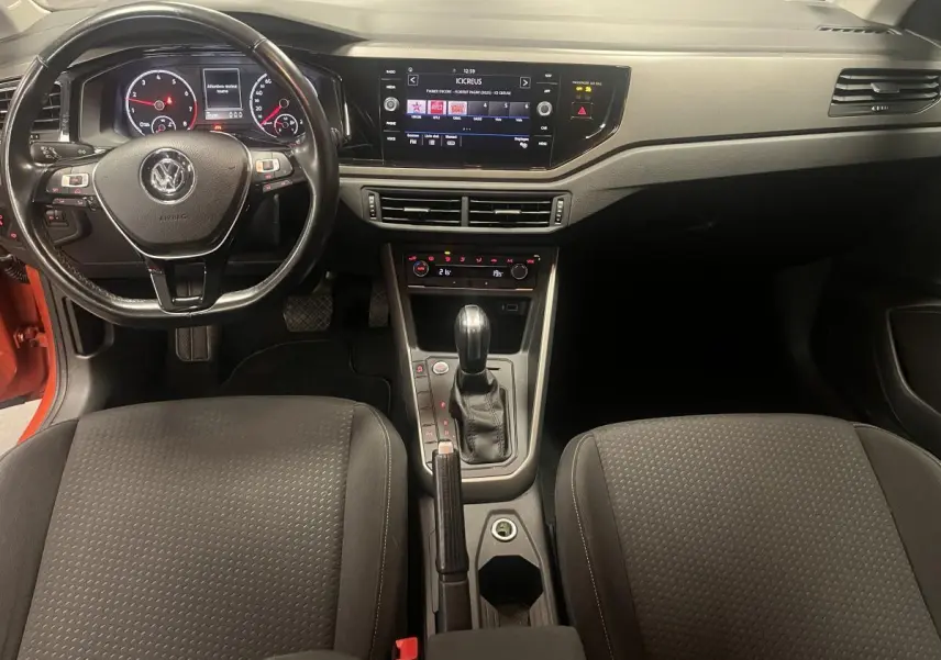 Vue intérieure avant de la Volkswagen Polo Lounge Business 2019, tableau de bord noir avec écran tactile et volant cuir multifonction.