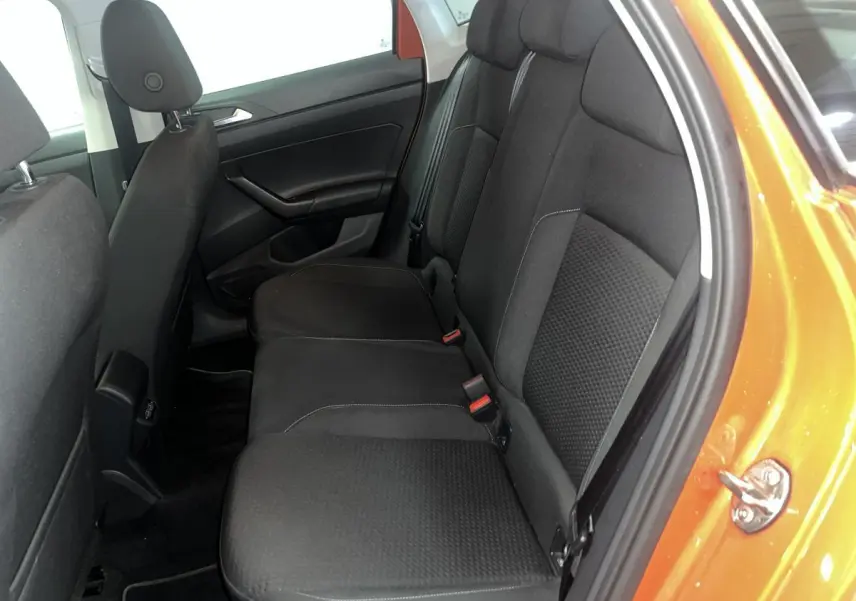 Vue côté droit de la banquette arrière noire dans une Volkswagen Polo orange 2019 avec porte ouverte.