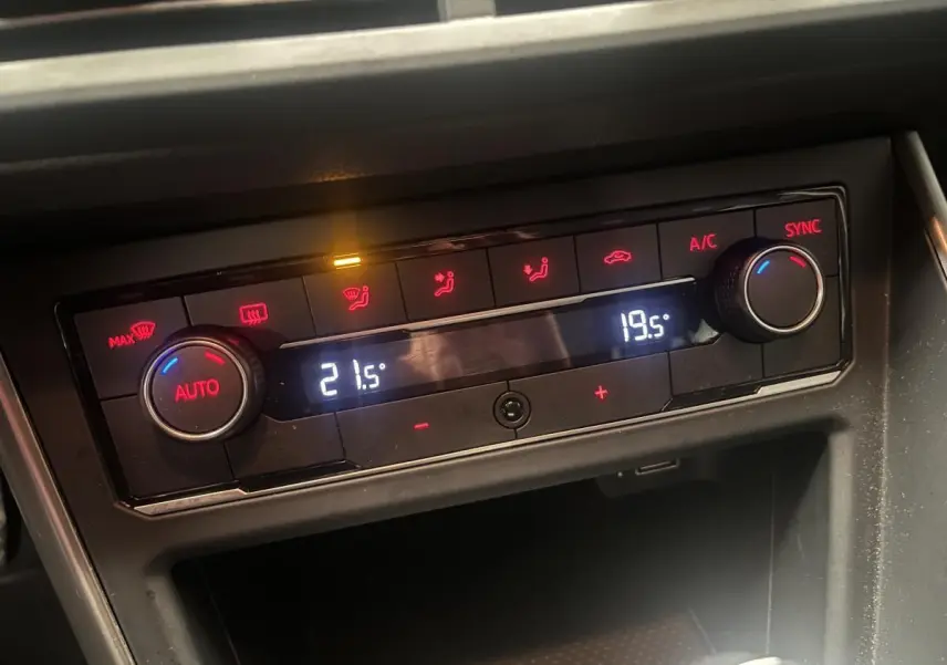 Panneau de climatisation automatique bi-zone avec réglages numériques dans une Volkswagen Polo orange 2019.