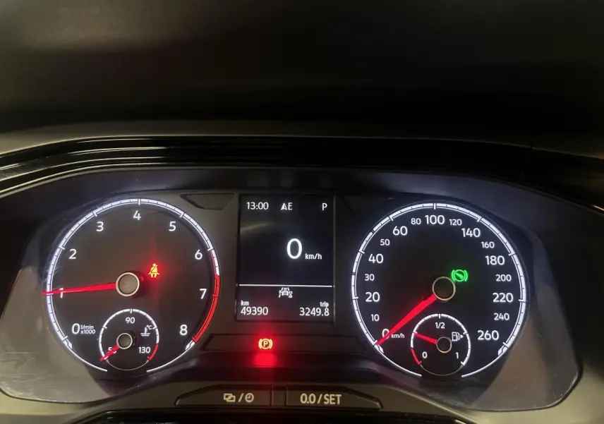 Tableau de bord numérique de Volkswagen Polo orange 2019, affichage vitesse à 0 km/h et témoins allumés.