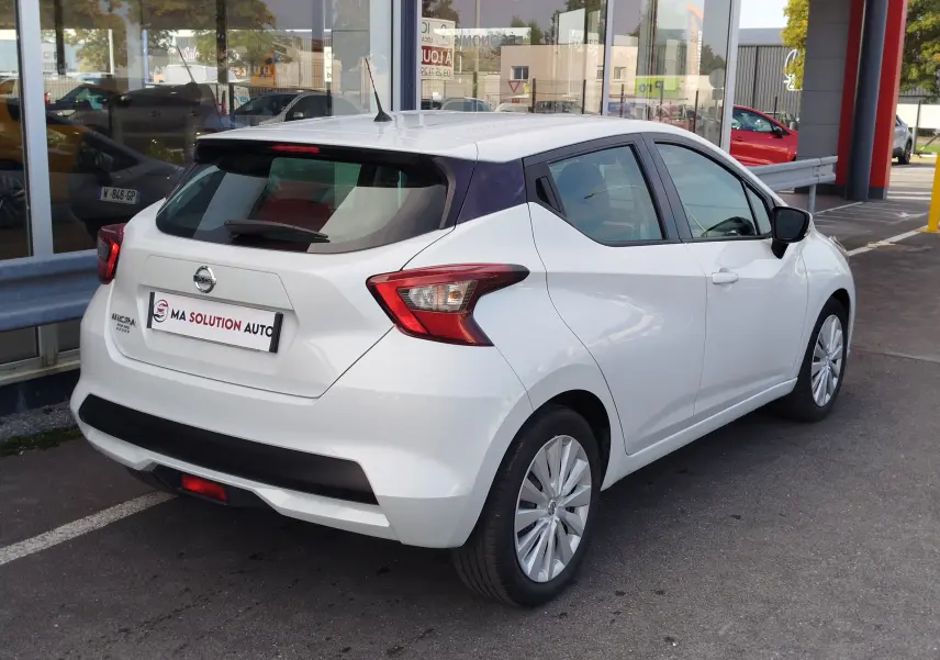 Vue 3/4 arrière droite d'une Nissan Micra blanche 2019 avec toit noir et feux arrière anguleux.