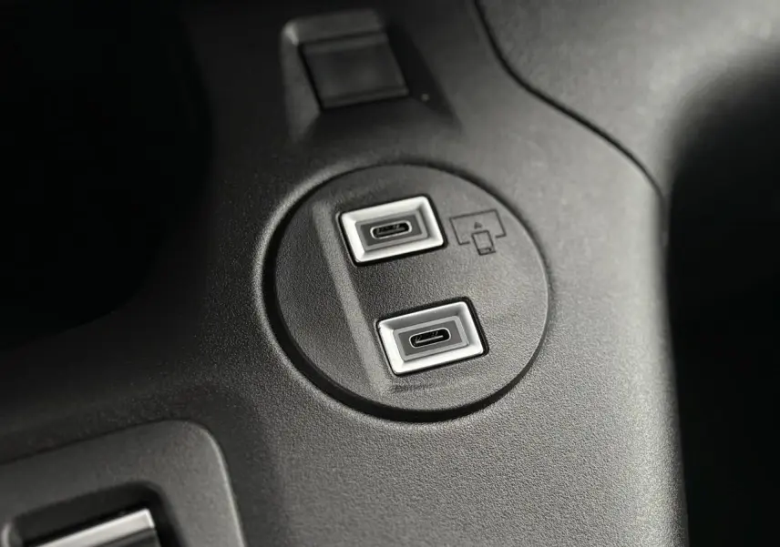 Gros plan sur deux ports USB-C intégrés dans la console centrale noire du Citroën Berlingo blanc Icy 2025.