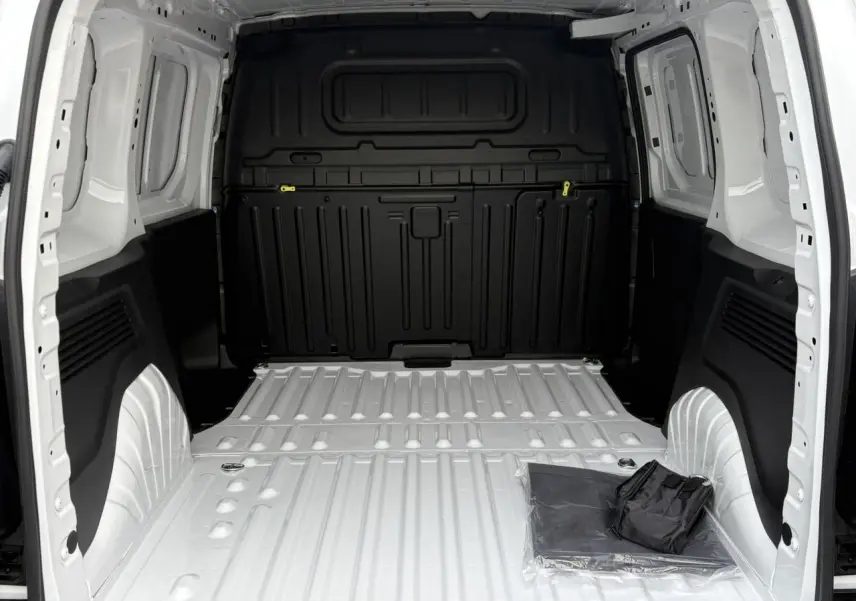 Vue intérieure arrière du Citroën Berlingo blanc Icy, montrant la zone de chargement tôlée et un kit de protection au sol.