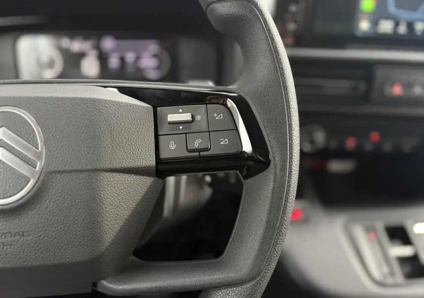 Gros plan sur la partie droite du volant du Citroën Berlingo 2025 avec commandes audio et téléphone intégrées.