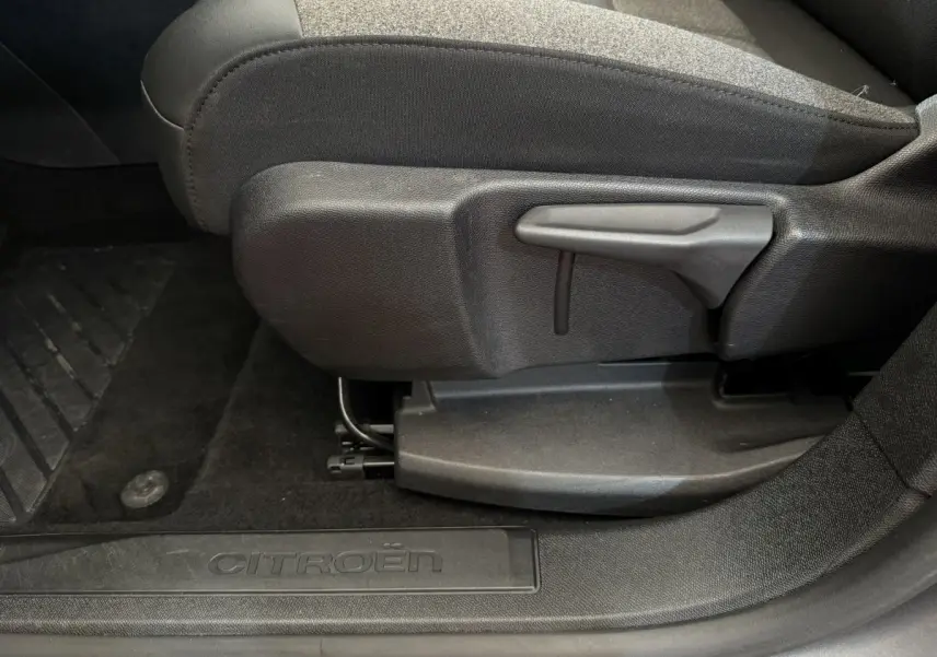 Détail côté gauche du siège avant noir et seuil de porte avec logo Citroën dans un C5 Aircross gris clair 2020.