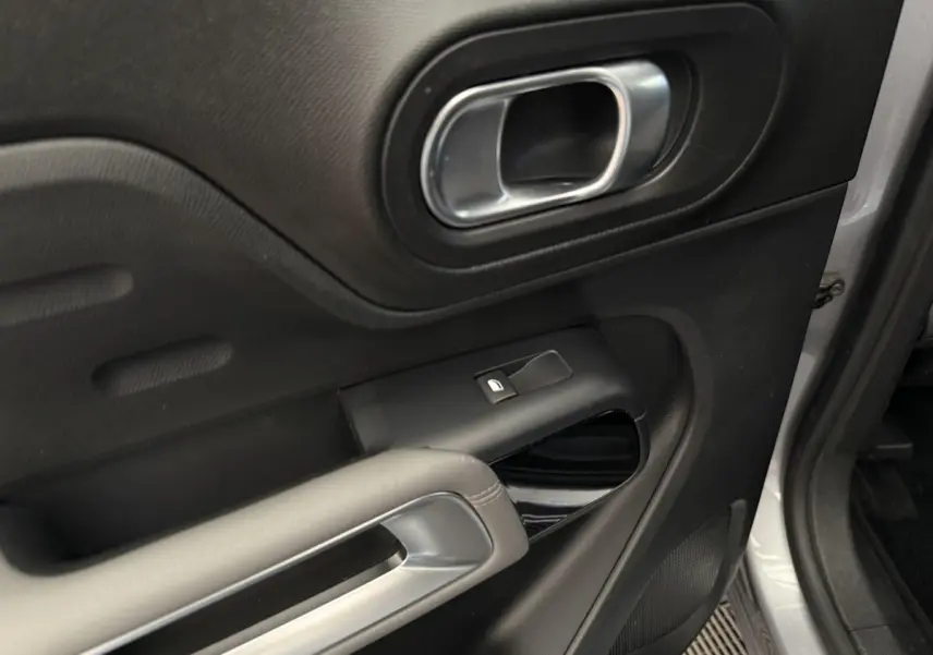 Gros plan sur la porte avant droite gris clair du Citroën C5 Aircross avec poignée et commande de vitre noire.