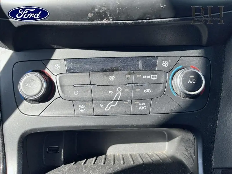 Panneau de commande de climatisation de Ford Focus blanc, vue rapprochée du tableau de bord central.