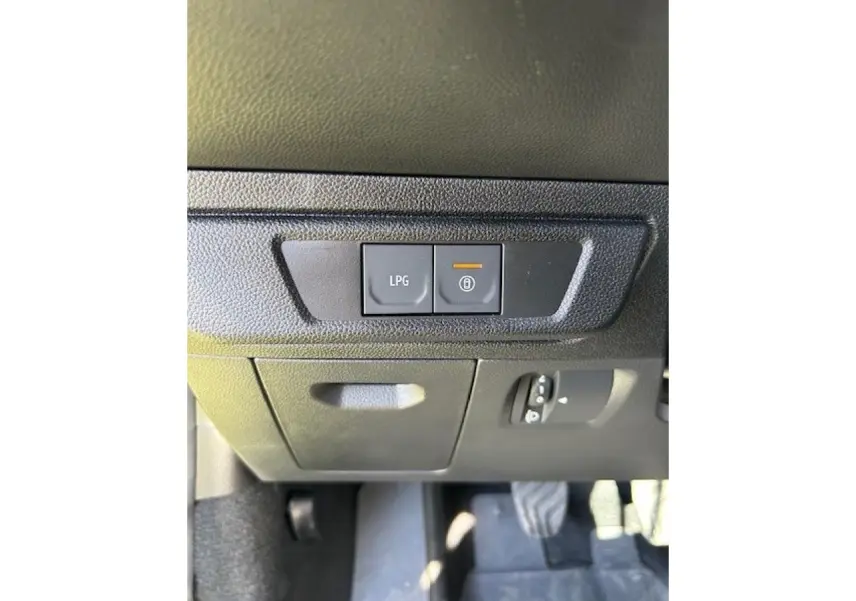 Détail intérieur montrant les boutons de commande LPG et verrouillage sous le tableau de bord noir du Dacia Sandero Stepway beige.
