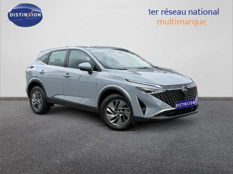 Nissan Qashqai 2025 gris Argile en 3/4 avant droit, avec calandre noire distinctive et jantes alliage.