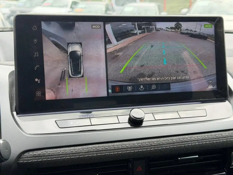 Écran tactile intérieur montrant la caméra de recul et vue panoramique 360° du Nissan Qashqai Gris Argile, tableau de bord moderne.