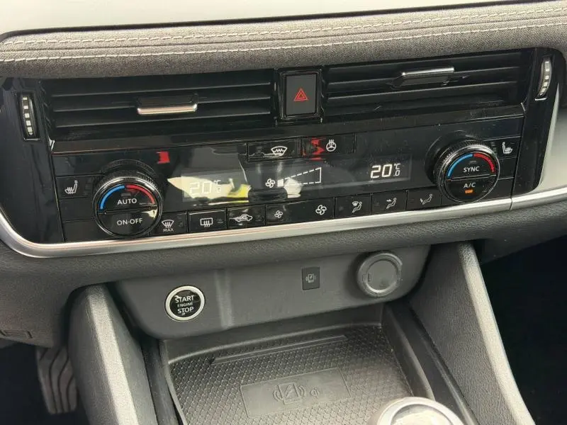 Vue rapprochée de la console centrale du Nissan Qashqai 2025, avec commandes climatisation bi-zone et bouton Start/Stop.