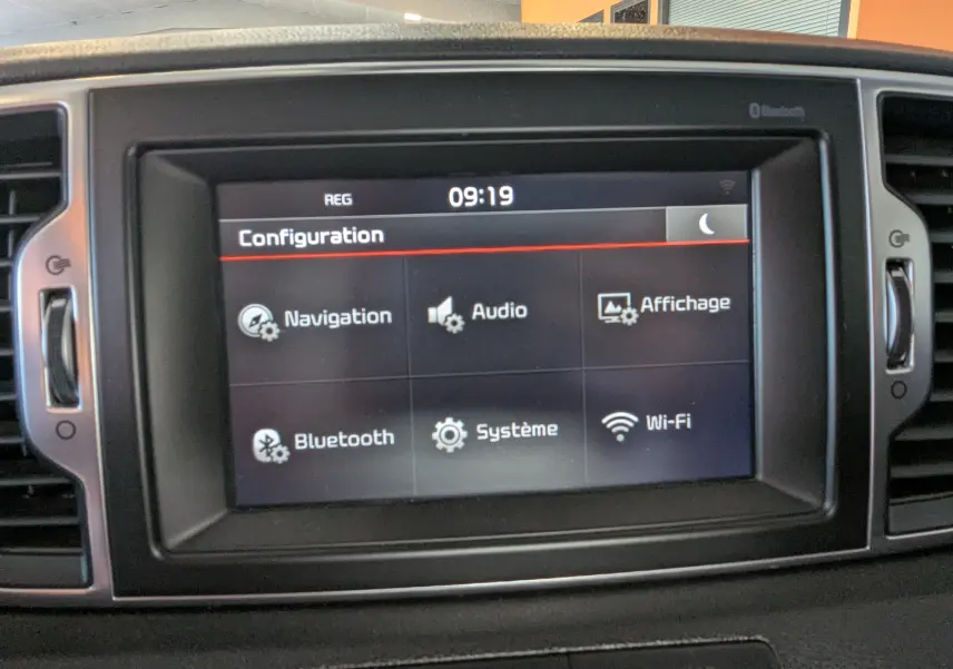 Écran tactile central du Kia Sportage gris 2016 affichant le menu configuration avec options navigation, audio et Wi-Fi.