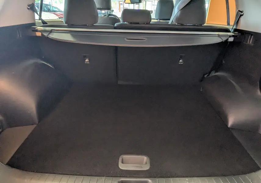 Vue du coffre spacieux d'un KIA Sportage gris 2016, avec cache-bagages et sièges arrière visibles.