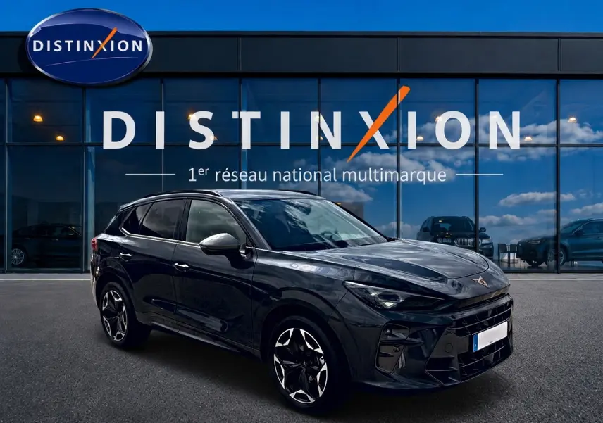 Vue 3/4 avant droit du CUPRA TERRAMAR gris timanfaya avec jantes alu noires et vitres surteintées, devant un showroom Distinxion.
