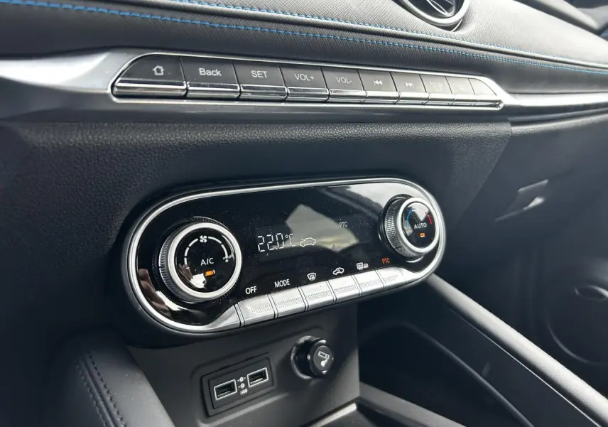 Détail de la console centrale noire avec commandes de climatisation et surpiqûres bleues du SERES 3 Luxury 2022.