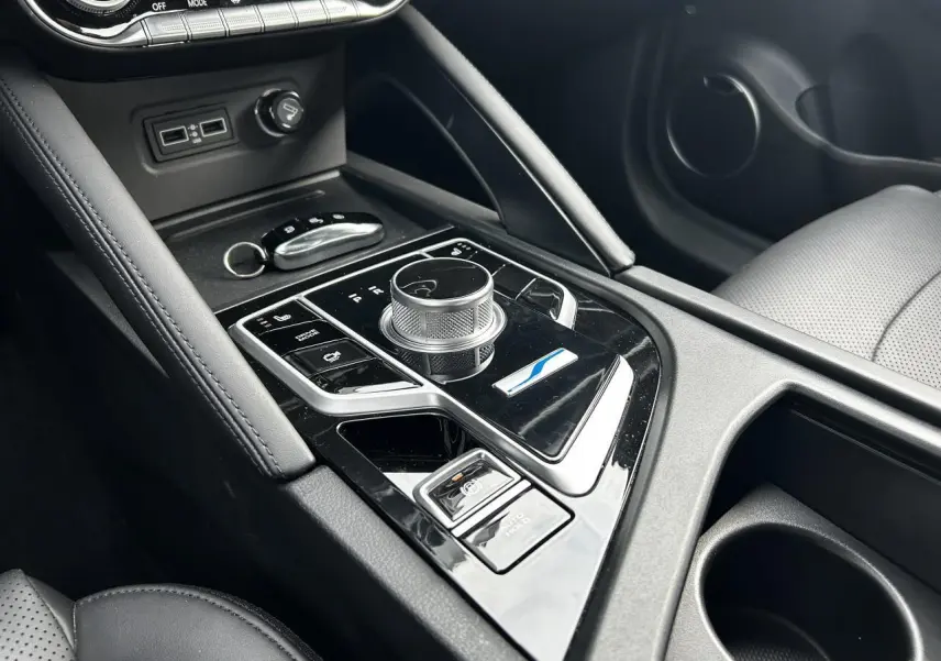 Vue rapprochée de la console centrale noire du SERES 3 163 Luxury 2022 avec molette de commande et bouton Auto-Hold.