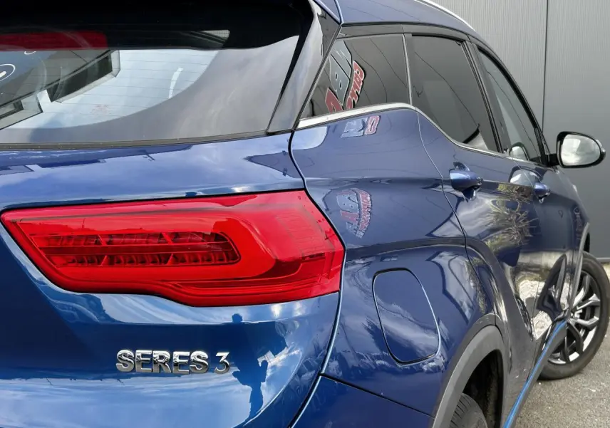 Vue 3/4 arrière droite du SUV électrique SERES 3 bleu avec feux arrière LED et vitres surteintées.