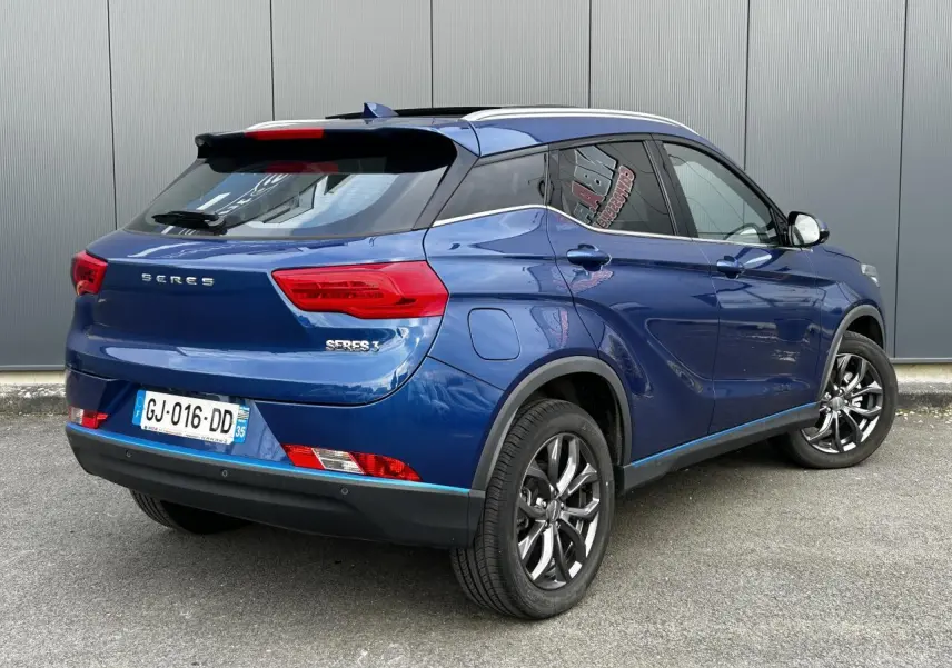 Vue 3/4 arrière droite du SUV électrique SERES 3 163 Luxury bleu avec toit panoramique et jantes aluminium.
