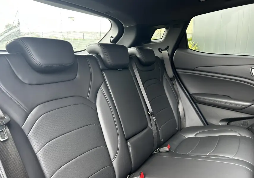 Vue intérieure sur les sièges arrière en cuir noir du SERES 3 163 Luxury, avec ceinture de sécurité et fenêtre latérale visible.