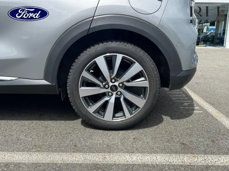 Gros plan sur la roue avant droite en jante alu du Ford Puma gris Solar Métallisée 2022, avec passage de roue noir.
