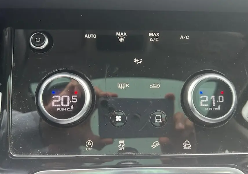 Gros plan sur la commande de climatisation bi-zone du Range Rover Evoque gris foncé, affichant 20,5°C et 21°C.