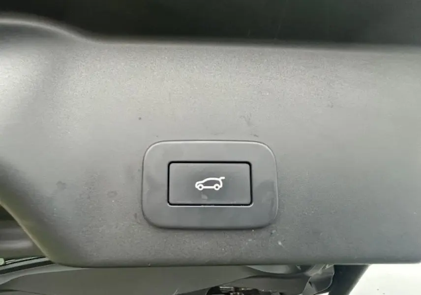 Bouton de hayon électrique mains libres sur le hayon gris foncé métallisé du Range Rover Evoque 2022 vue intérieure arrière.