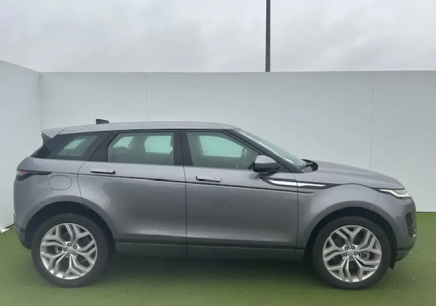 Profil droit du Range Rover Evoque gris foncé métal avec jantes 20 pouces et lignes épurées modernes.