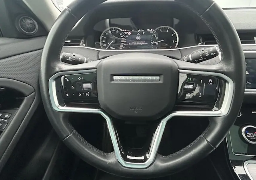 Volant en cuir noir du Range Rover Evoque 2022 avec commandes intégrées et tableau de bord numérique visible en arrière-plan