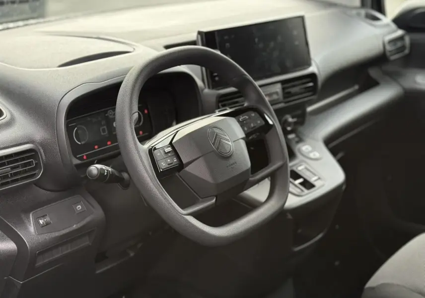 Intérieur du Citroën Berlingo 2025 noir Perla, vue côté conducteur sur le volant multifonction et l'écran tactile central.