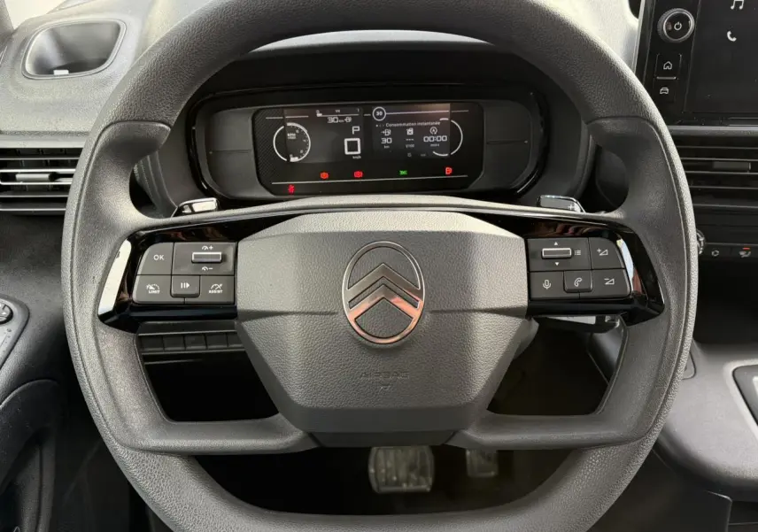 Vue rapprochée du volant multifonctions noir et du tableau de bord numérique du Citroën Berlingo 2025 Van M.