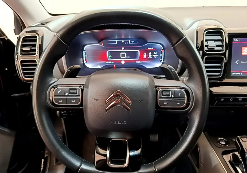 Vue rapprochée du volant cuir noir de la Citroën C5 Aircross 2020 avec tableau de bord digital et commandes intégrées.