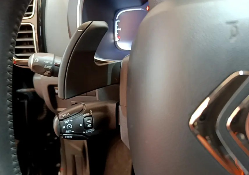 Gros plan sur la commande de régulateur de vitesse à gauche du volant cuir du Citroën C5 Aircross noir 2020.