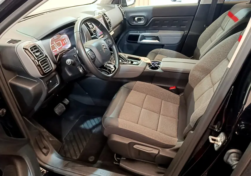 Intérieur avant droit du Citroën C5 Aircross noir 2020, volant cuir et sièges tissu gris avec console centrale moderne.