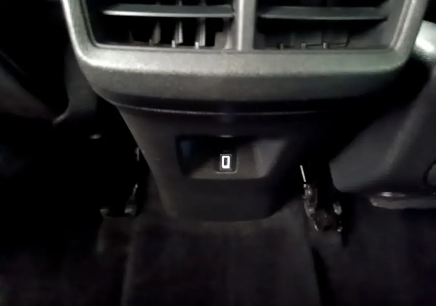 Prise 12V située sous la console centrale arrière du Citroën C5 Aircross noir, avec ventilation au-dessus.